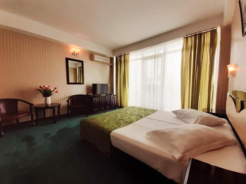a hotel room with a large bed and a window at Hotel Smarald in Eforie Nord