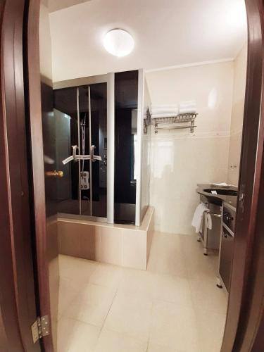 a bathroom with a mirror and a cross on the wall at Hotel Smarald in Eforie Nord