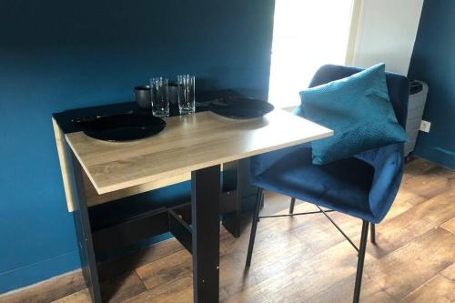 - une table en bois avec une chaise et des verres dans l'établissement Nouveau L'escapade Chinonaise, à Chinon
