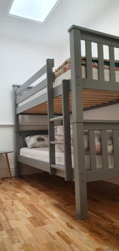a bunk bed in a room with a wooden floor at Drift Away Apartment in Westward Ho