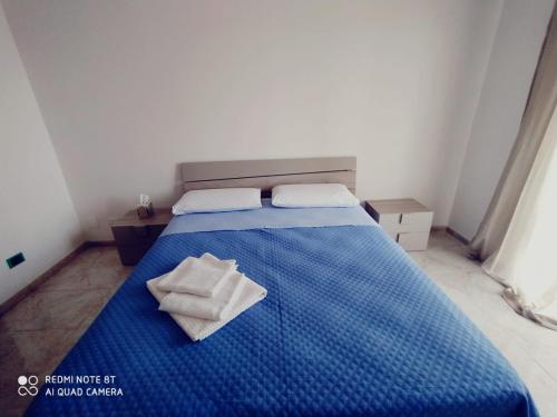 a blue bed with two towels on top of it at APPARTAMENTO SANTUCCI in Rodi Garganico