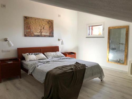 a bedroom with a bed and a picture on the wall at La Casetta di Sù in Maracalagonis