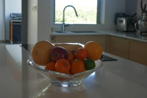 a bowl of fruit on a counter in a kitchen at Villa Kumquat, avec piscine Clévacances 4 clés in Petit-Bourg