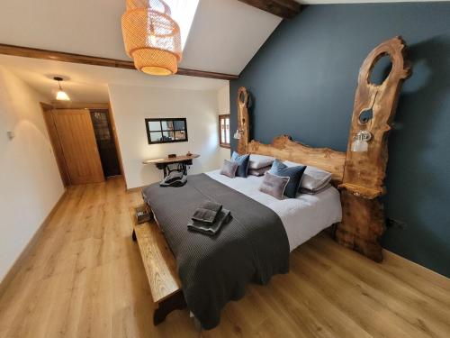a bedroom with a large bed with a wooden headboard at Loch Lomond Blair Byre in Rowardennan