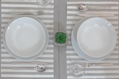 - une table avec une plaque de cuisson et des couverts blancs dans l'établissement Cantinho da Quintã, à Mesão Frio