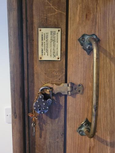 a wooden door with a metal door knocker on it at Loch Lomond Blair Byre in Rowardennan