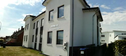 ein weißes Gebäude mit Seitenfenstern in der Unterkunft Gepflegtes und schönes Ferienapartment im Neubau in Travemünde