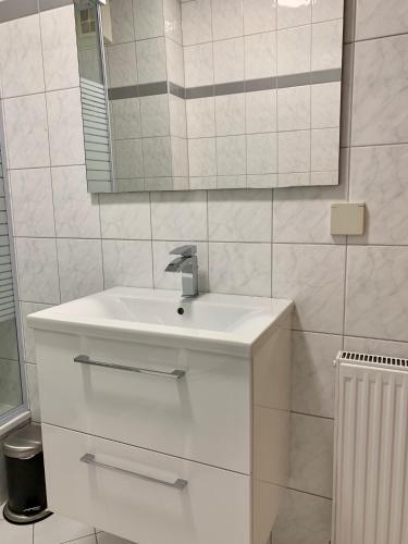a white bathroom with a sink and a mirror at Appartement Lilienthal in Klagenfurt