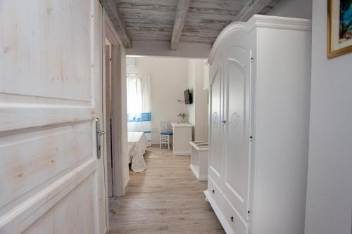 a hallway with a room with white walls and wooden floors at La Casa in Collina - affittacamere con vista mare in Lu Lioni