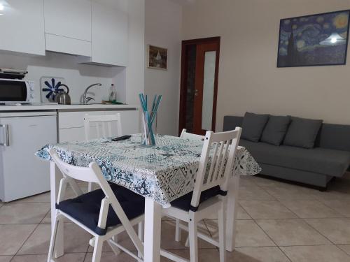 eine Küche mit einem Tisch, Stühlen, einem Tisch und einem Sofa in der Unterkunft Nonnacettyhouse in Torre del Greco
