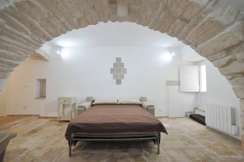sypialnia z dużym łóżkiem w kamiennej ścianie w obiekcie GaDa Home -centro storico - w mieście Martina Franca
