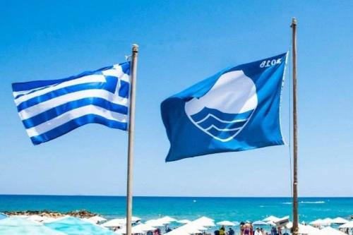 two blue and white flags on a beach at Q luxury rooms Perea center in Perea