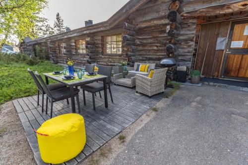 eine Terrasse mit einem Tisch und Stühlen vor einer Blockhütte in der Unterkunft Kuukkeli Log Houses Teerenpesä - Superior Suite A49 in Saariselkä