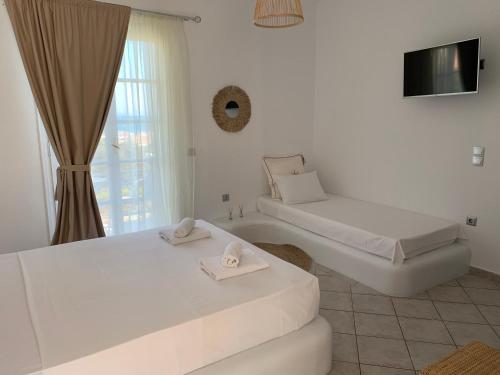 a white room with two beds and a window at villa of the god in Skala