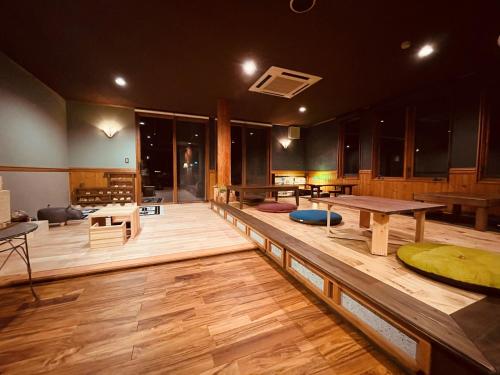 Großes Zimmer mit Holzböden, Tischen und Stühlen in der Unterkunft Nikko Akarinoyado Villa Revage in Nikko