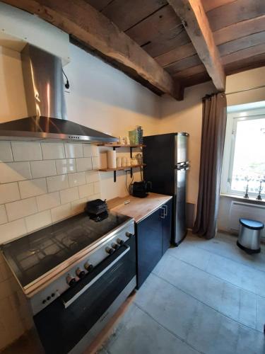 - une cuisine avec une cuisinière dans l'établissement Luxe gîte met authentieke kamers in de Creuse, France, à Vallières