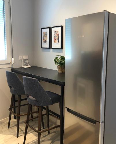 a black table with two chairs and a refrigerator at Angel Suites in Nicosia