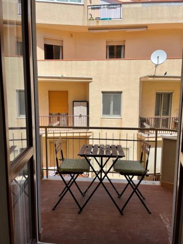 einen Tisch und Stühle auf dem Balkon eines Gebäudes in der Unterkunft Sa Vivenda Suite in Alghero