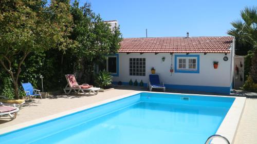 a villa with a swimming pool in front of a house at Santo António's Guesthouse in Cascais