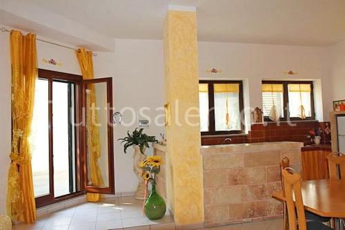 uma cozinha e sala de estar com uma mesa e uma banheira em La Casa Di Madia em Gagliano del Capo