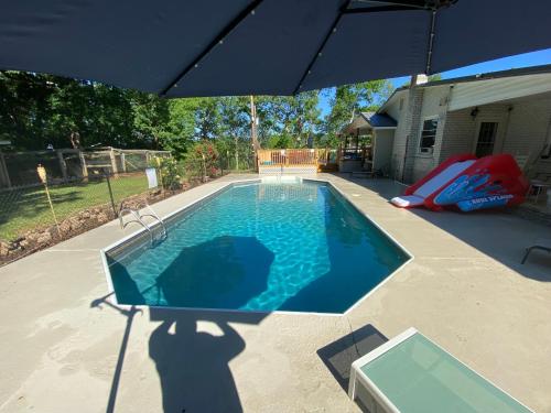 a person standing under an umbrella next to a swimming pool at Apartment in the Country in Etowah