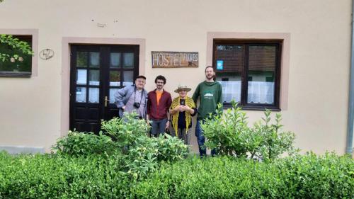Un grupo de personas de pie frente a un edificio. en Hostel Flores, en Kostanjevac