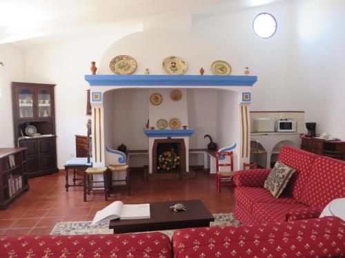 a living room with a red couch and a fireplace at Sol Poente in Évora