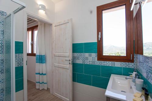 a bathroom with a sink and a mirror at La Casa in Collina - affittacamere con vista mare in Lu Lioni