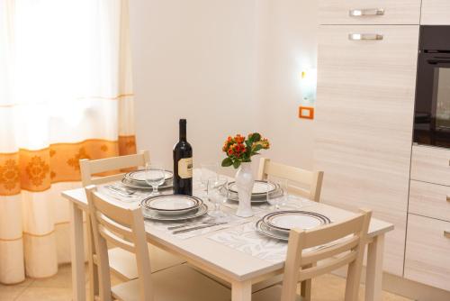 a dining room table with a bottle of wine and glasses at Melalidone in Orosei