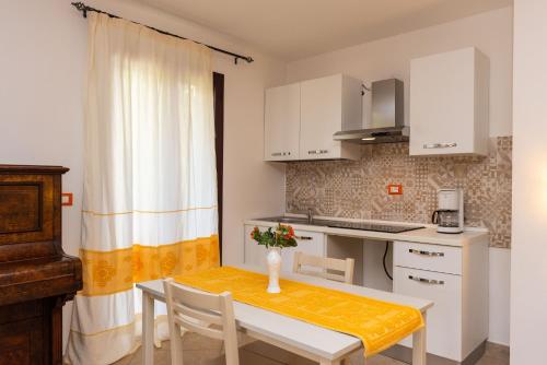 a small kitchen with a table with a vase of flowers on it at Melalidone in Orosei
