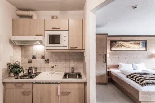 a small kitchen with a sink and a bed at Vera Monti in Holzgau