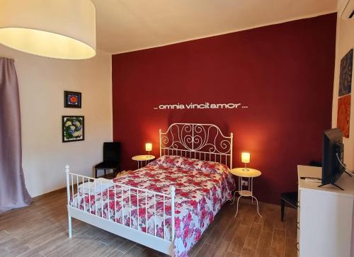 1 dormitorio con 1 cama con pared roja en Ercole' s Home, en Caserta