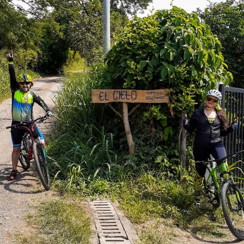 two people on bikes next to a sign on a trail at El Cielo Biohospedaje - Refugio Sostenible en la Naturaleza in Tena