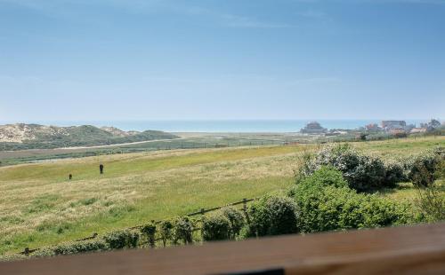 a field of grass with the ocean in the background at VILLA LA FORT BELLE VUE in Ambleteuse