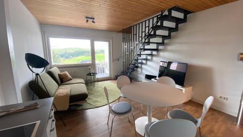 uma sala de estar com uma mesa e cadeiras e uma escadaria em AUSZEIT em Obertal