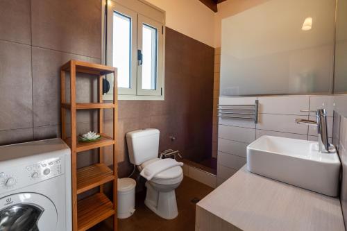 ein Badezimmer mit einem weißen WC und einem Waschbecken in der Unterkunft Achlia Beach Villa in Achlia