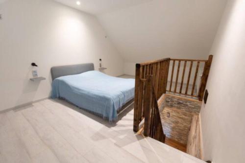 ein Schlafzimmer mit einem Bett und einer Holztreppe in der Unterkunft Loft bourguignon au pied des sources de la Seine in Chanceaux