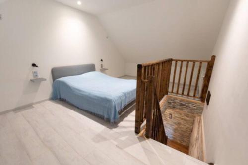 a bedroom with a bed and a wooden staircase at Loft bourguignon au pied des sources de la Seine in Chanceaux