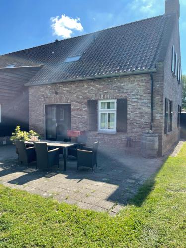 a table and chairs in front of a brick house at PrinsHaerlyck Overnachten in Made