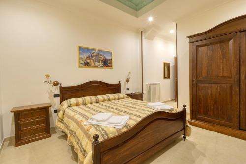 una camera con un grande letto e un armadio in legno di B&B il Baglio a Nicotera
