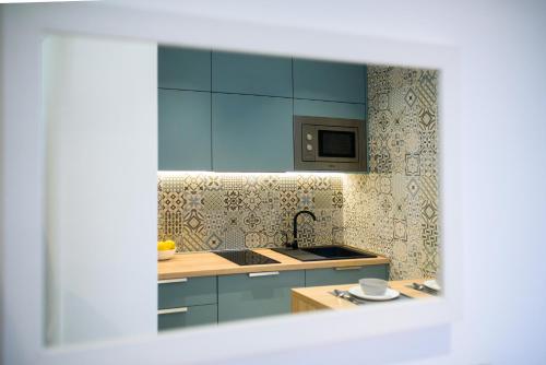 a kitchen with blue cabinets and a sink at Villa Leoni in Dubrovnik