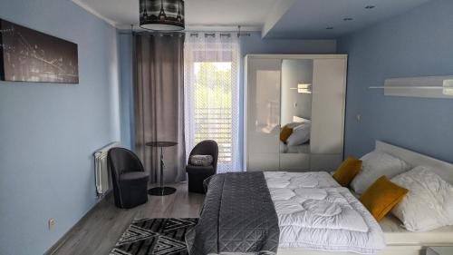 a bedroom with blue walls and a bed and a window at Apartamenty Przemko in Rewal