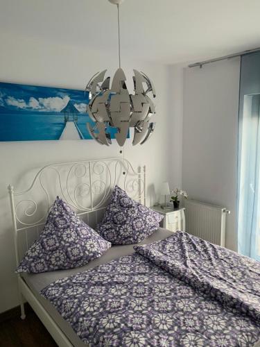 ジブヌフにあるIve's Golden Gardenia Seasideのベッドルーム1室(紫のシーツとシャンデリア付)