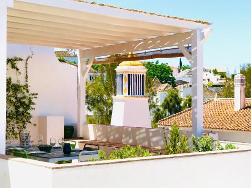 a white pergola on top of a house at Casa Do Gilao in Tavira
