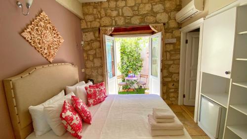 a bedroom with a bed with red and white pillows at Maison d'Azur Alaçatı in Alacati