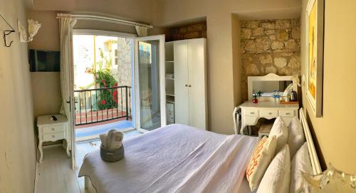 a bedroom with a bed and a door to a balcony at Maison d'Azur Alaçatı in Alacati