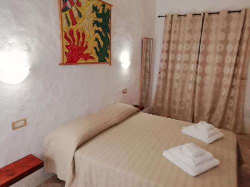1 dormitorio con 1 cama con 2 toallas en Beni Benìus, en Teulada