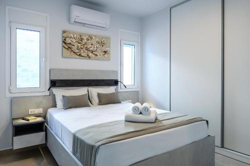 a bedroom with a large bed with two towels on it at Makrygialos Long Beach Villa 1 in Makry Gialos