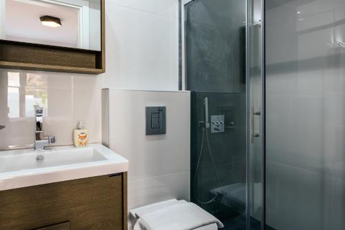 a bathroom with a shower and a sink at Makrygialos Long Beach Villa 1 in Makry Gialos