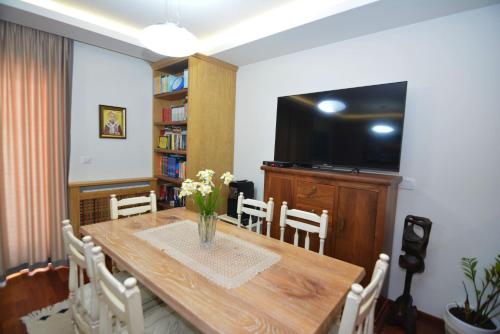 a dining room with a table and a television at Apartments Olive in Kotor